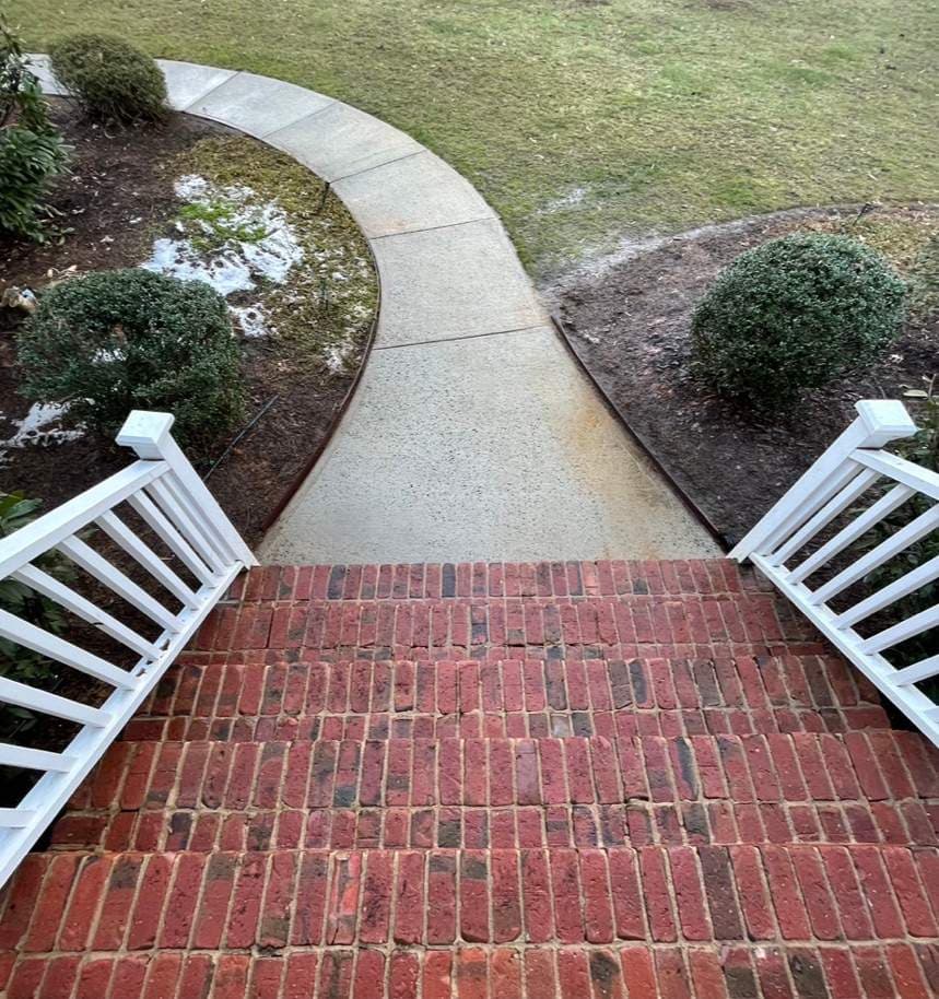 Clean concrete walkway and brick steps after pressure washing