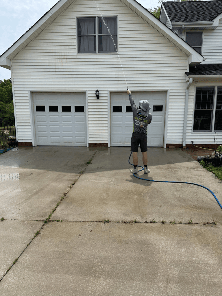 Sully's Pressure Washing technician soft-washing a two-story home exterior